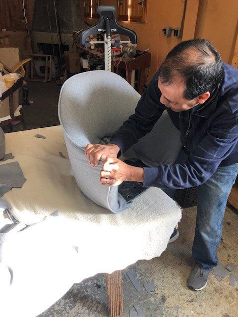 A man is working on a chair in a workshop