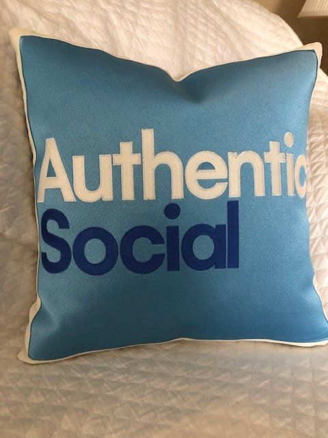 A blue pillow that says authentic social on it