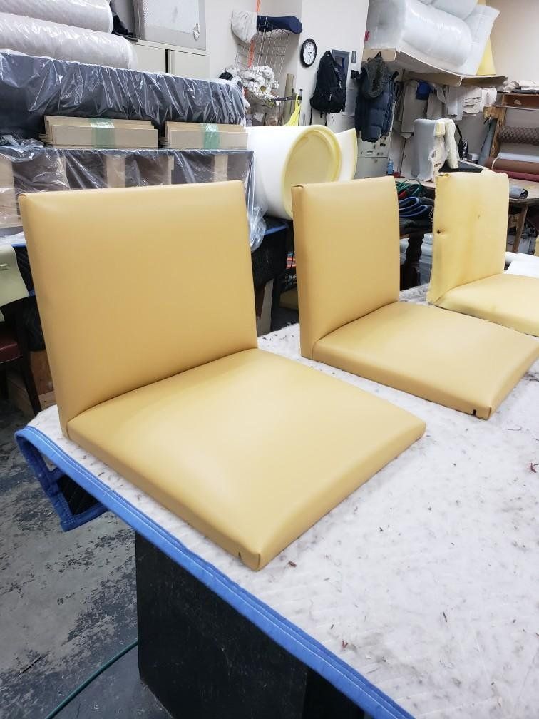 Two yellow chair cushions are sitting on top of a table.