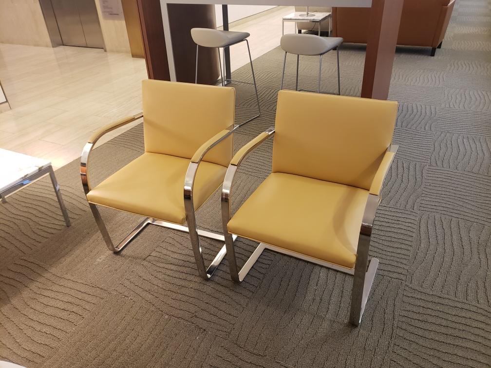 Two yellow chairs are sitting next to each other in a room.