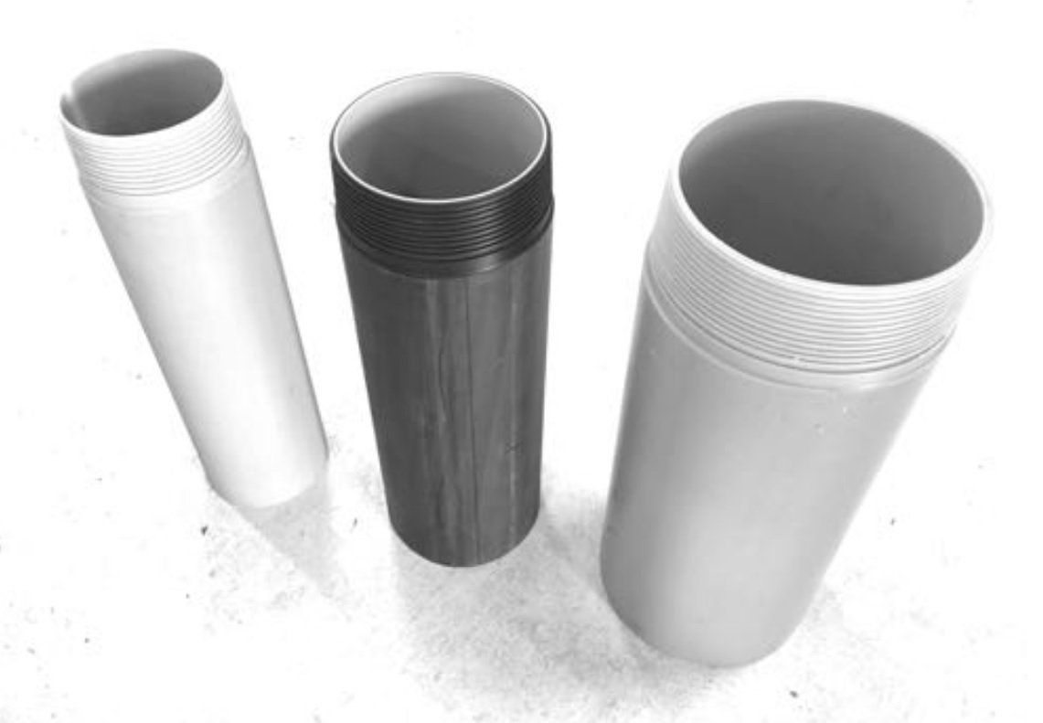 Four different colored cylinders are sitting on a white surface.