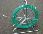 A green hose reel is sitting on top of a metal stand.