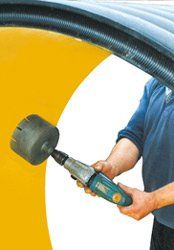 A man is holding a drill and a rubber mallet.