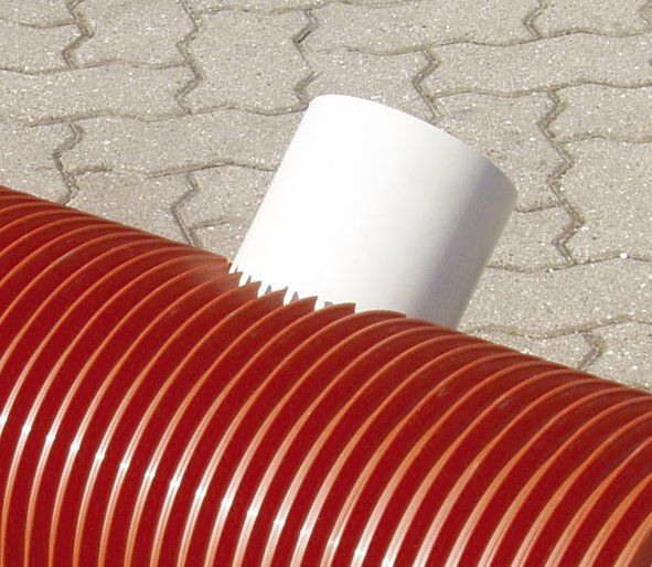 A close up of a red and white pipe on a brick sidewalk