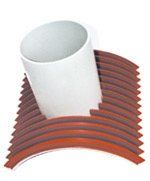 A white cup is sitting on top of a stack of red pipes.