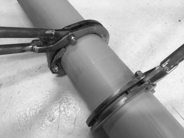 A black and white photo of a pipe with a pair of pliers attached to it.