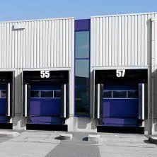 A row of blue loading doors on the side of a building.