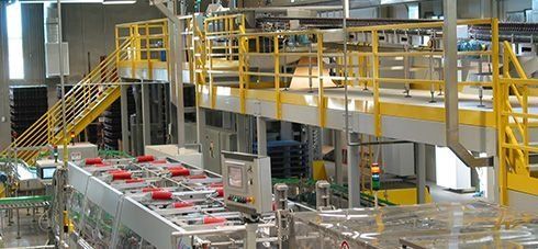 A factory with a yellow railing and stairs