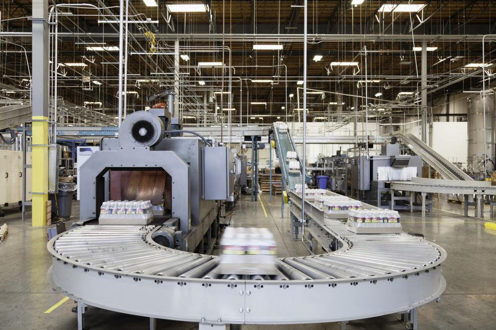 A conveyor belt is moving boxes in a factory.