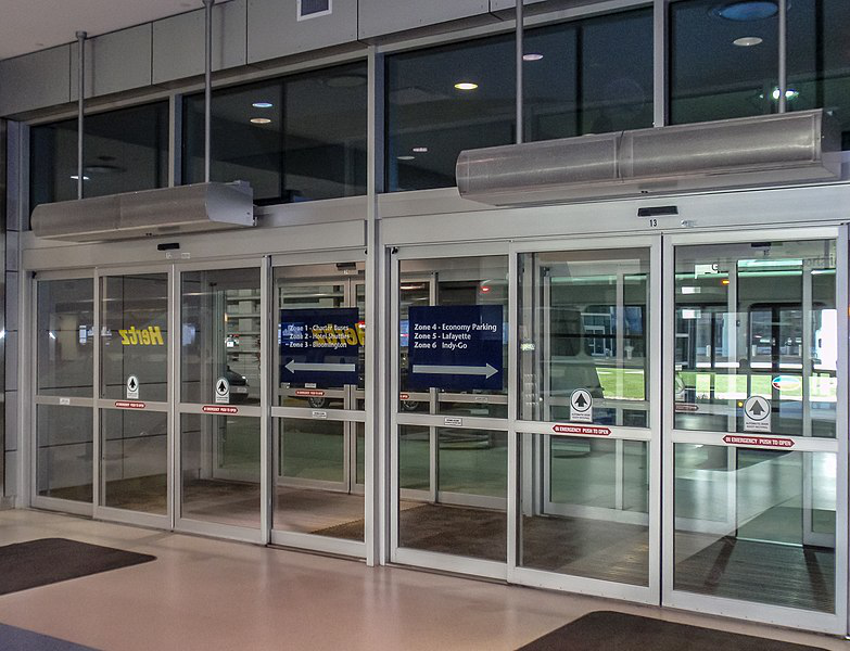 A building with sliding glass doors and a sign that says subway