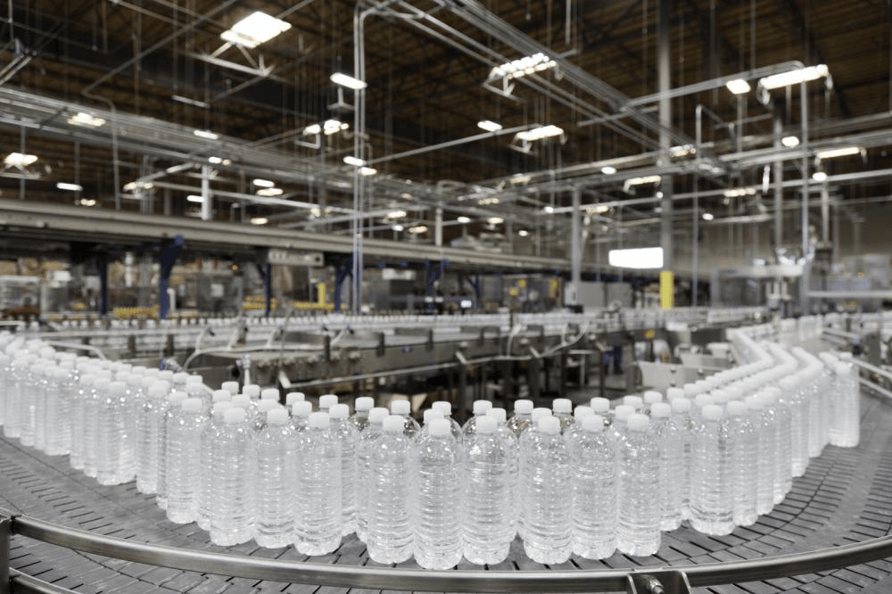 A conveyor belt filled with bottles of water in a factory.