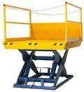 A yellow scissor lift with a railing on a white background.