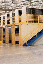 A warehouse with stairs leading up to a second floor.