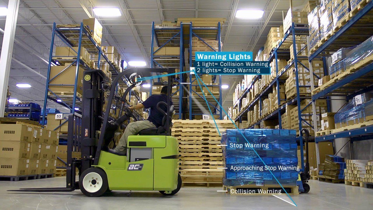 A man is driving a forklift in a warehouse.