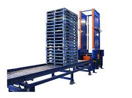A machine is moving pallets on a conveyor belt.