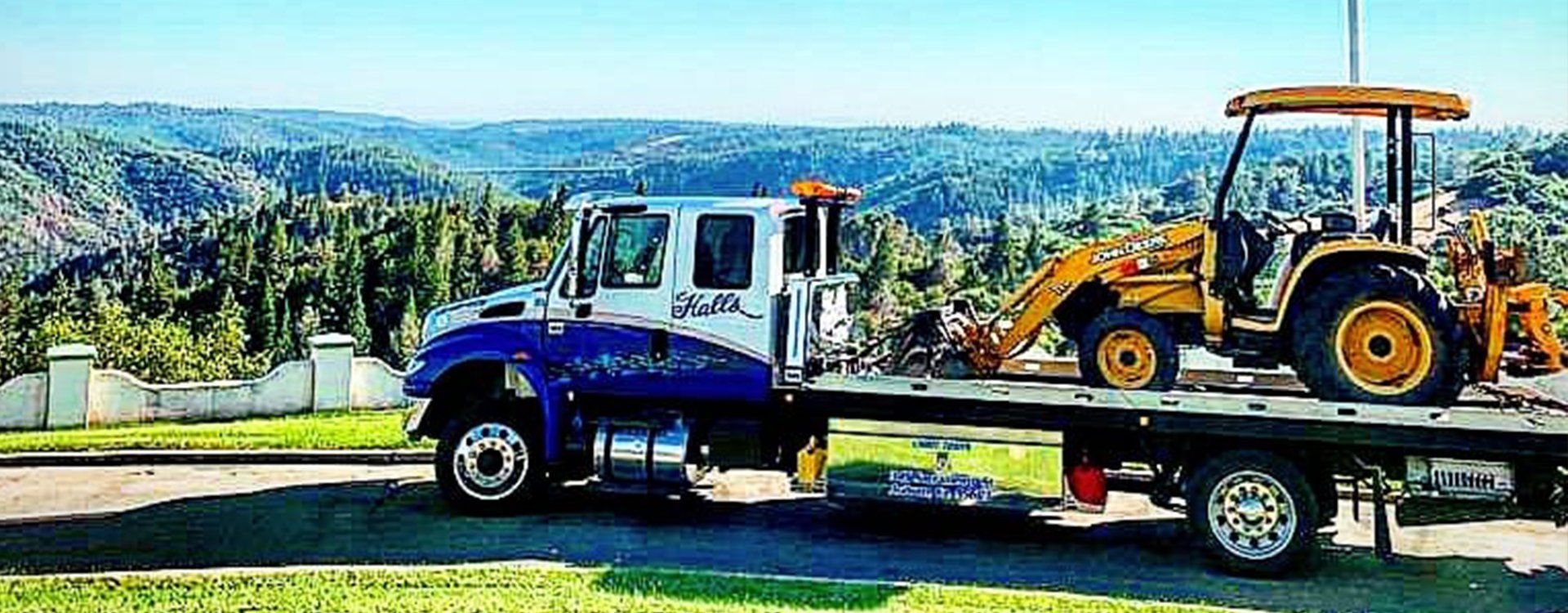 Truck carrier with mini vans at road — Auburn, CA — Hall’s Towing