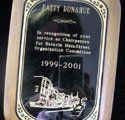 A wooden plaque with a picture of a building on it.