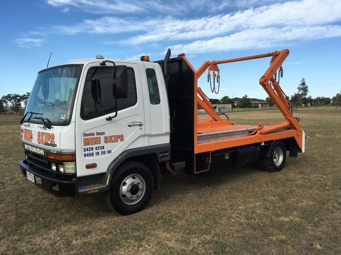 Macedon Ranges Mini Skips truck with skip bin lifting arms in a paddock