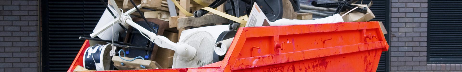 Orange skip bin loaded with household waste ready for collection