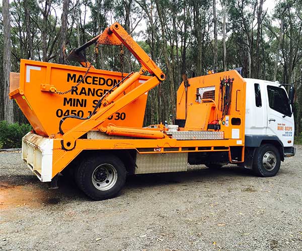 Macedon Ranges Mini Skips truck loaded with an orange skip bin