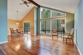 An empty living room with hardwood floors and a ceiling fan.