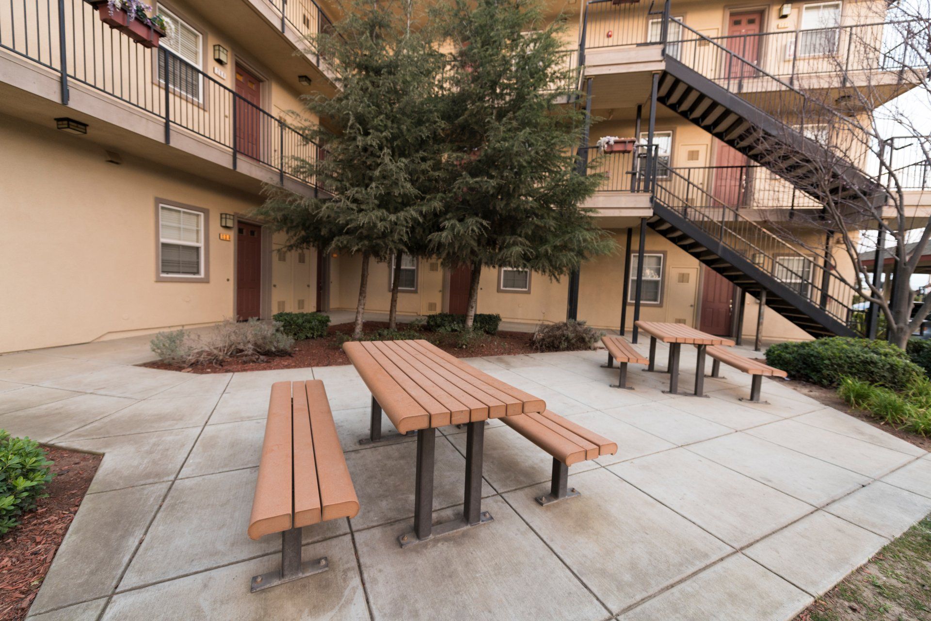 A picnic table and benches in front of a building