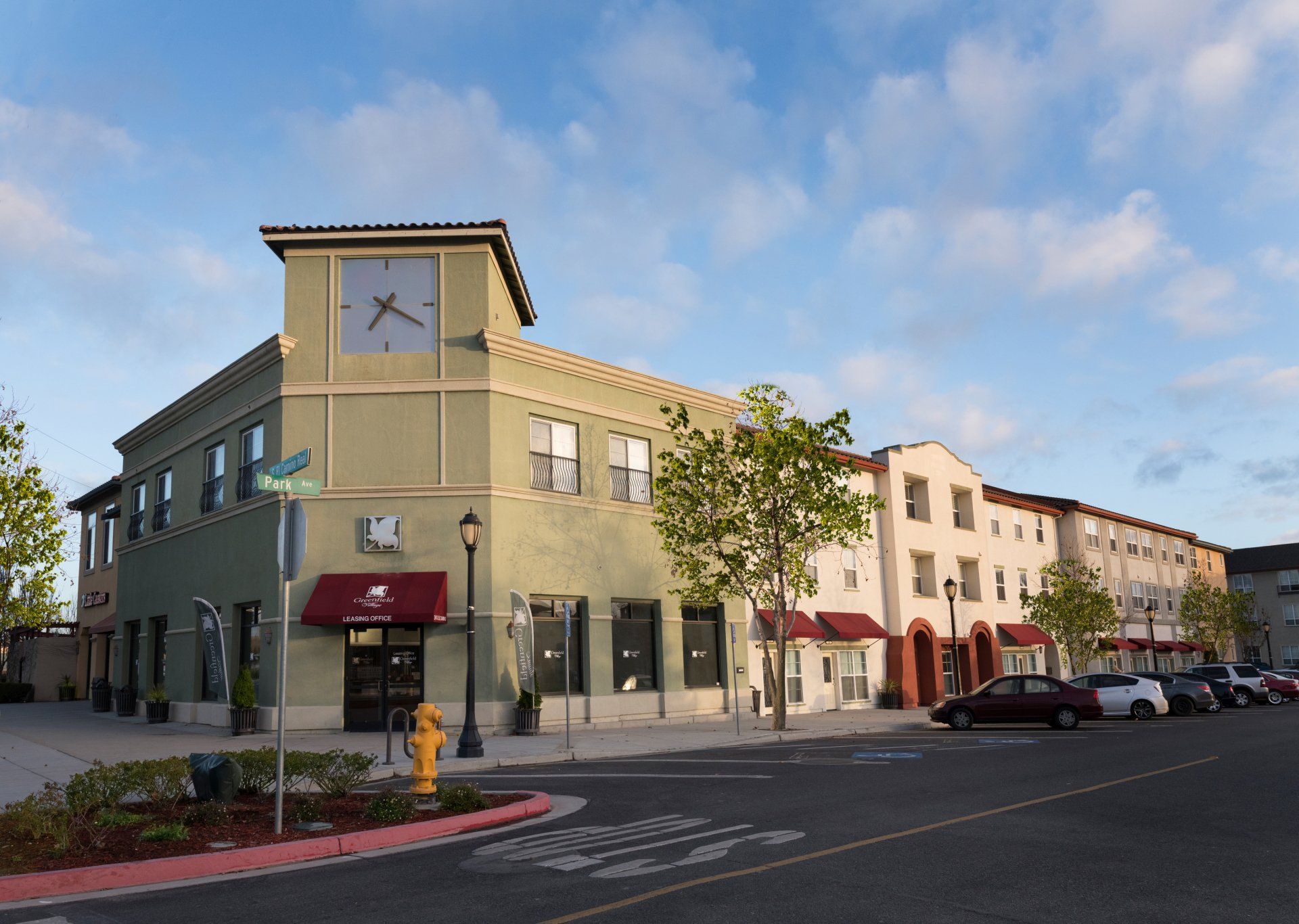 A green building with a clock on the top of it