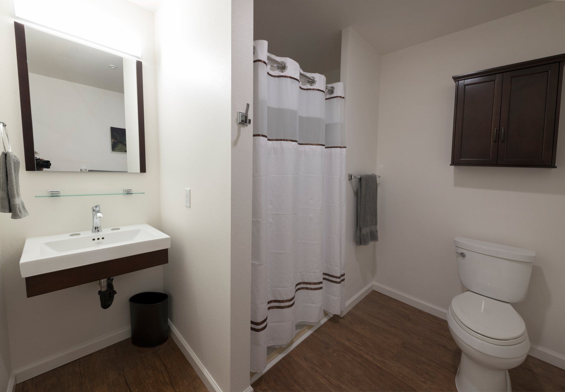 A bathroom with a toilet, a sink and a mirror