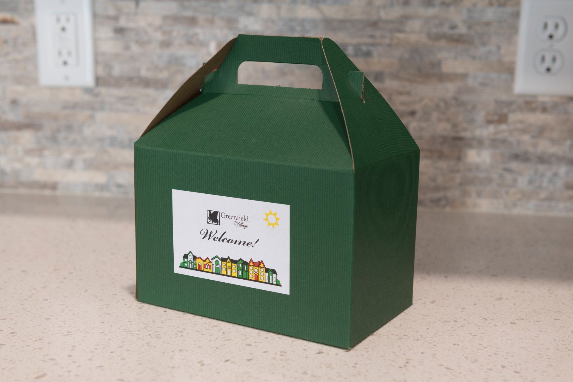 A green box with a sticker on it that says Greenfield Village Welcome!
