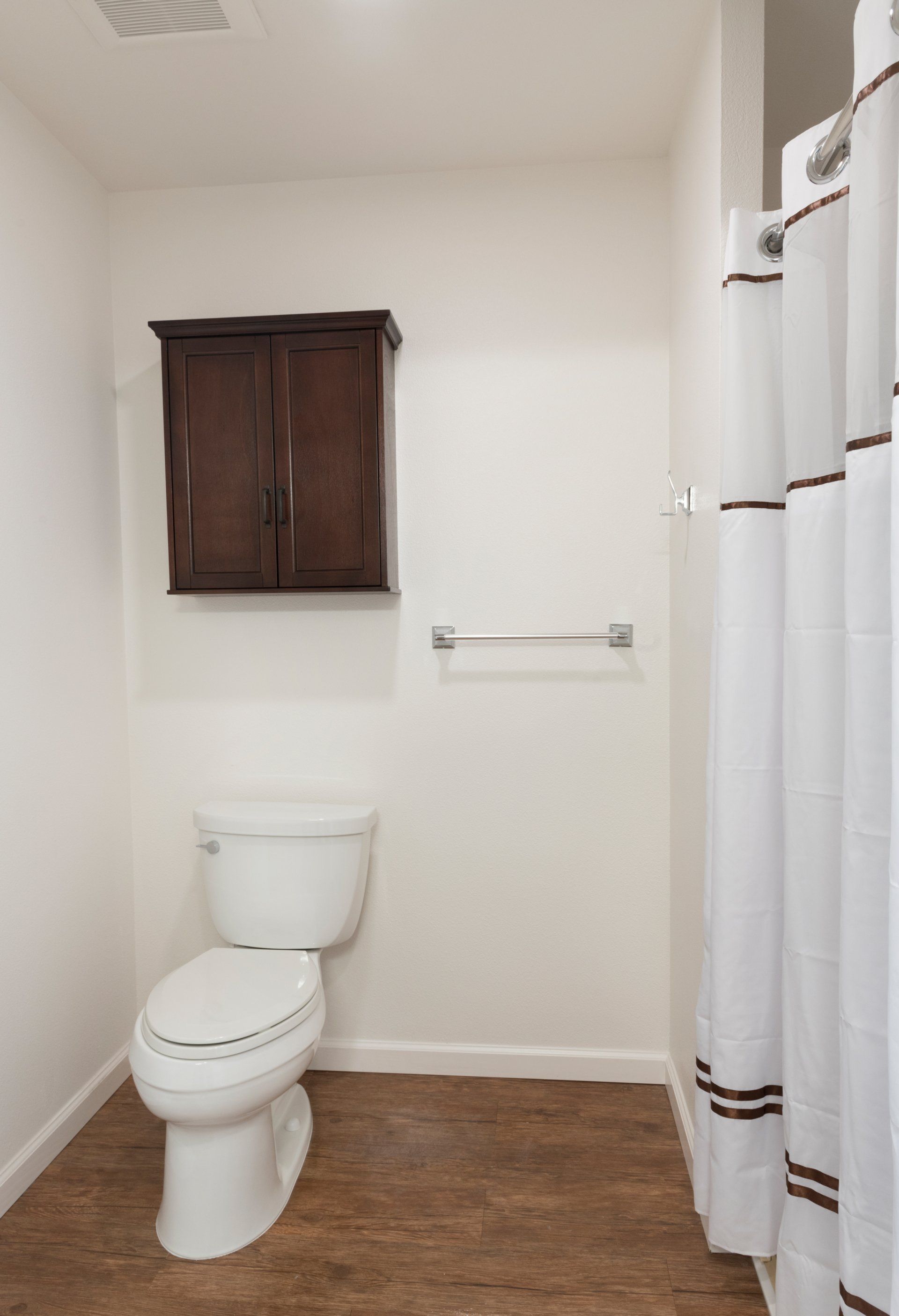 A bathroom with a toilet and a shower curtain