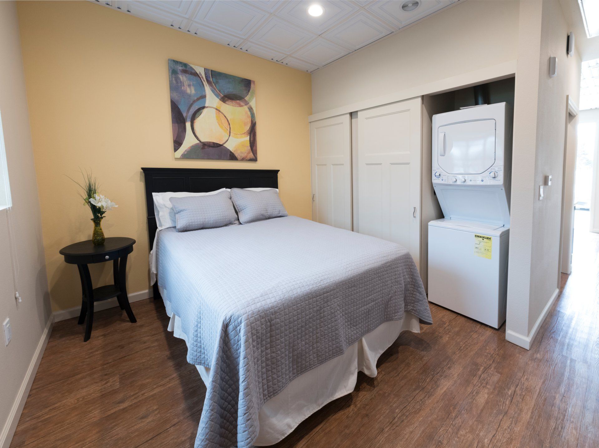 A bedroom with a bed and a washer and dryer