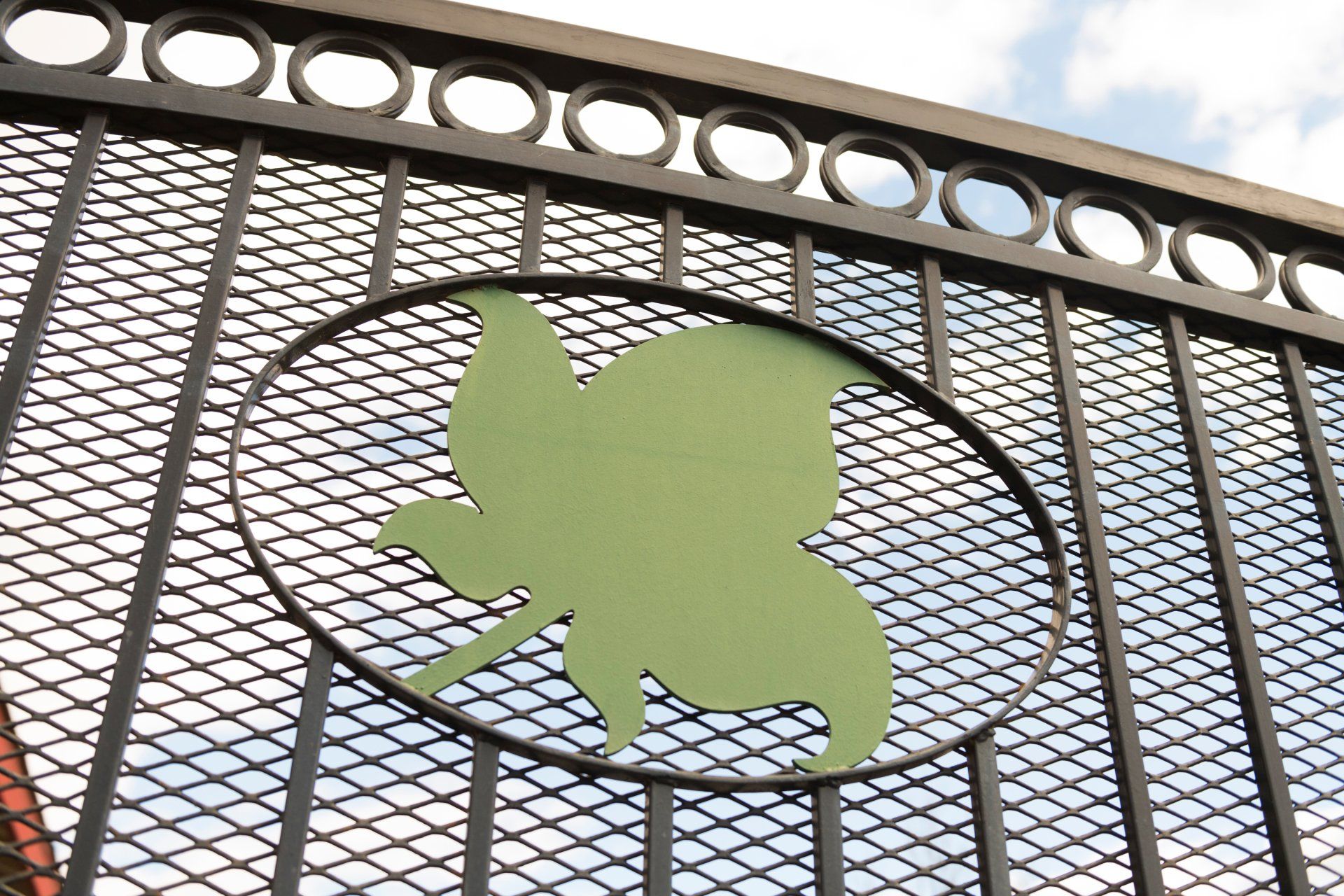 A metal fence with a green leaf in the middle