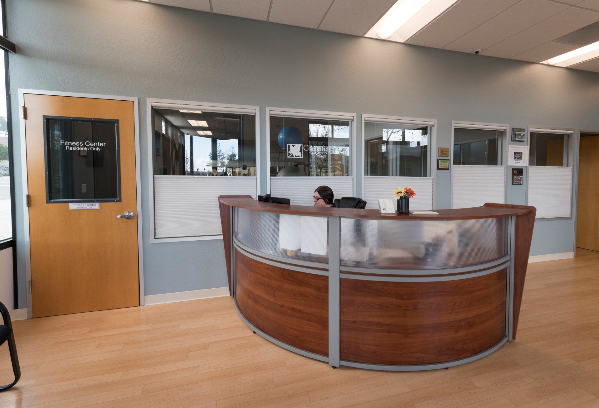A reception area with a curved wooden desk