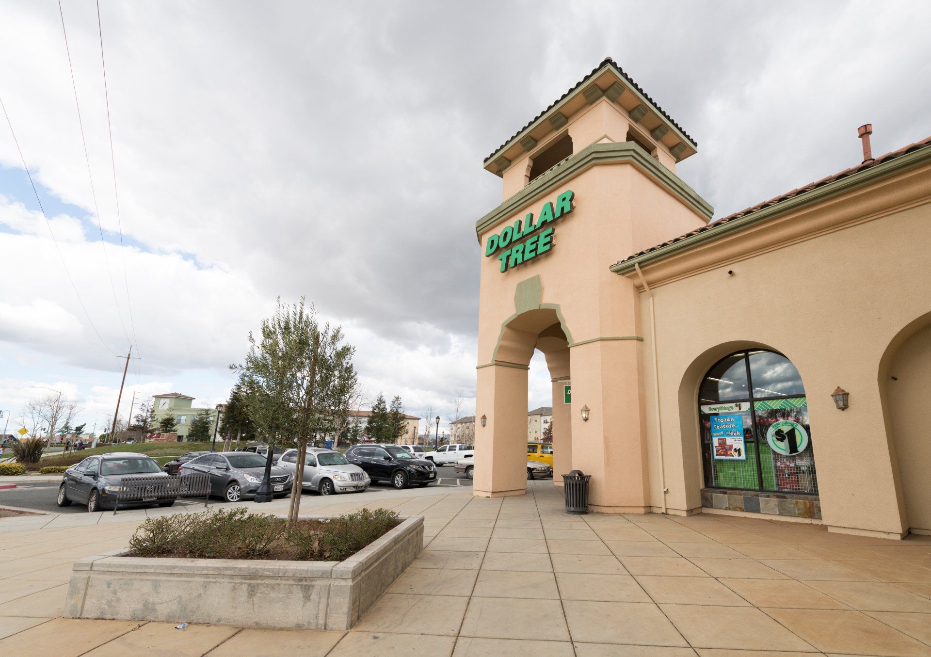 A dollar tree store with cars parked in front of it