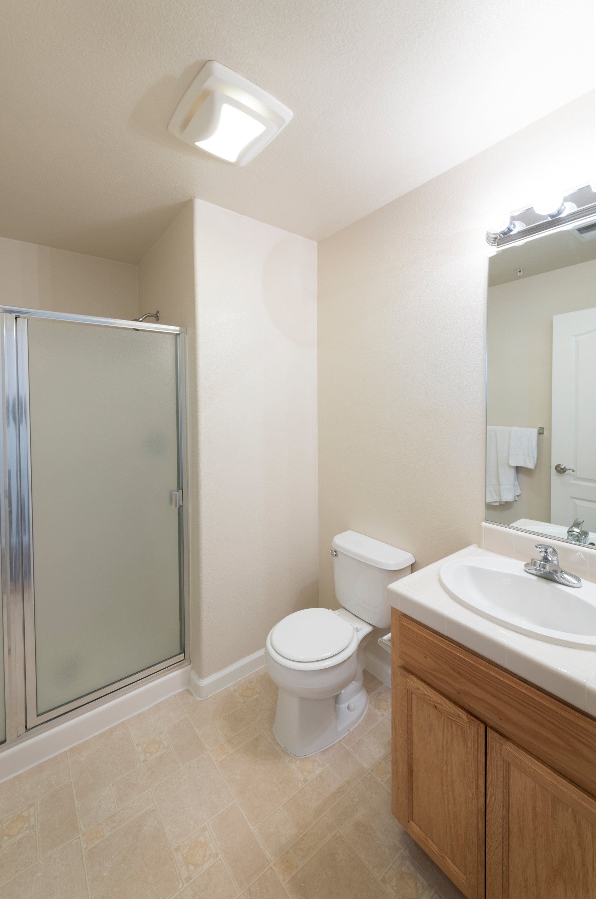 A bathroom with a toilet a sink and a shower