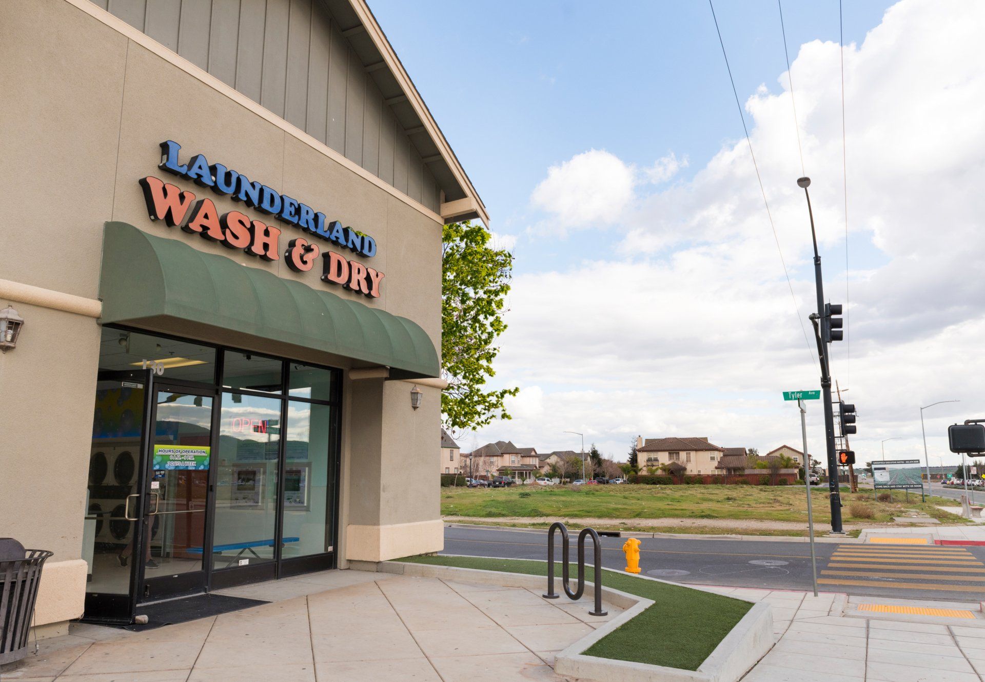 A laundromat with a green awning on the side of it