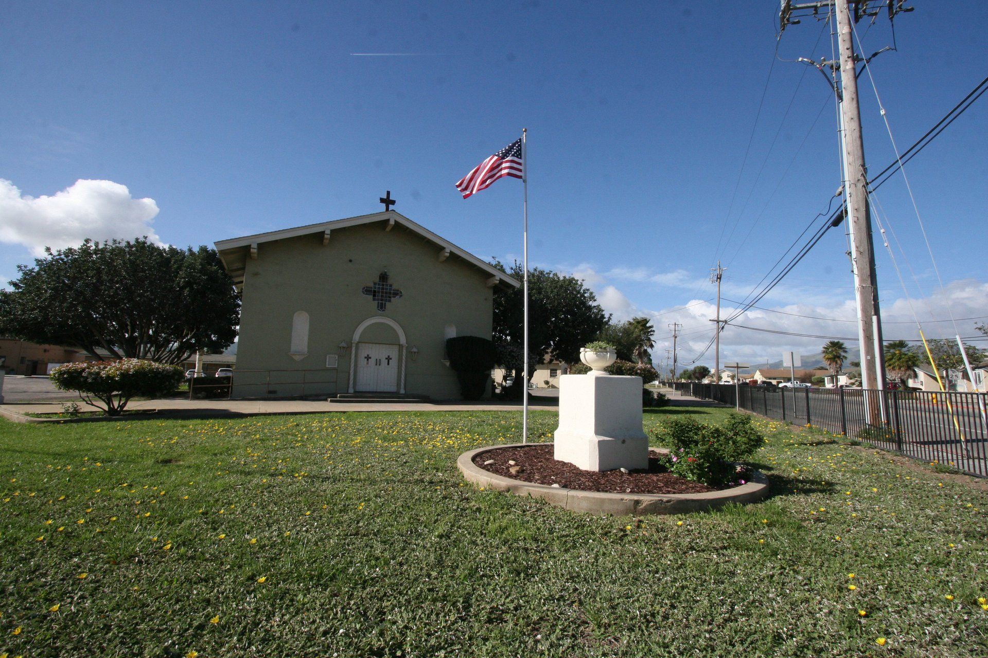 An american flag is flying in front of a church