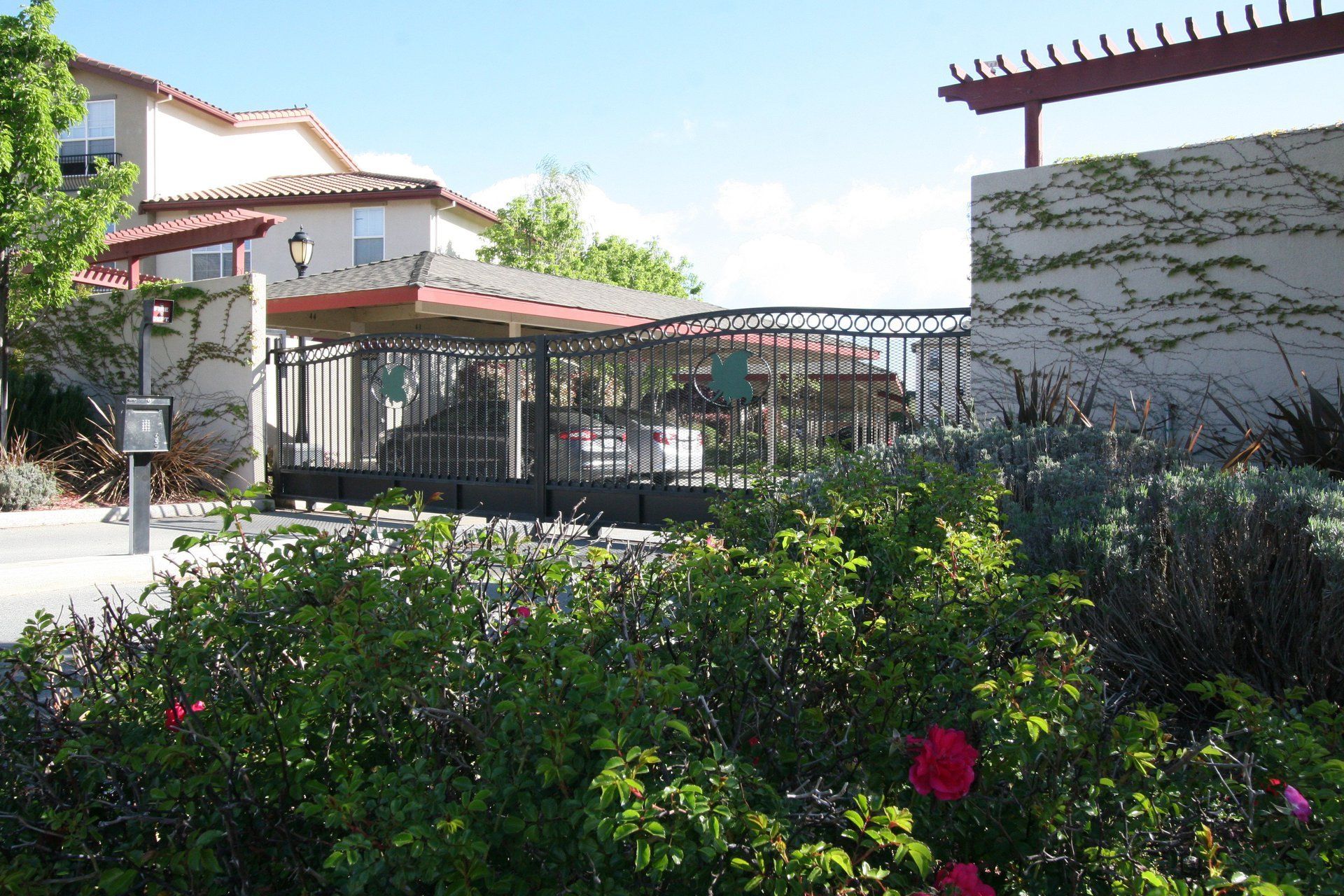A fenced in area with flowers in front of a building