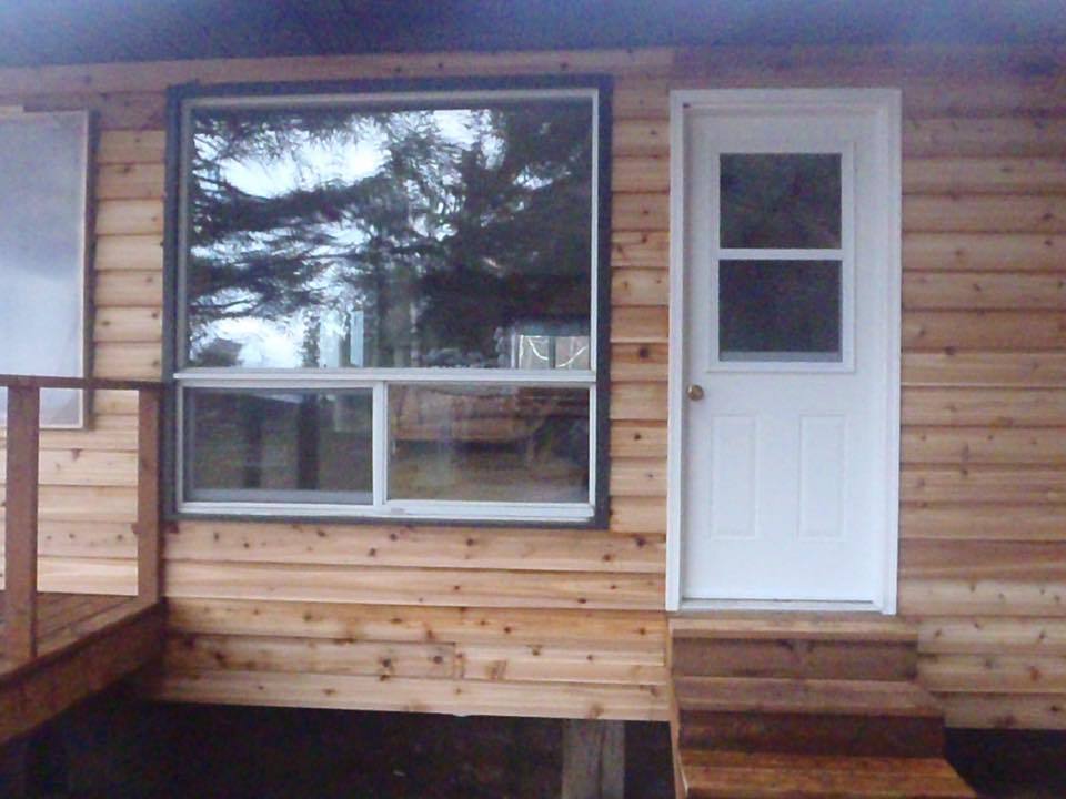 A wooden house with a white door and window