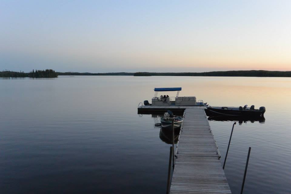 A boat is docked at a dock on a lake.
