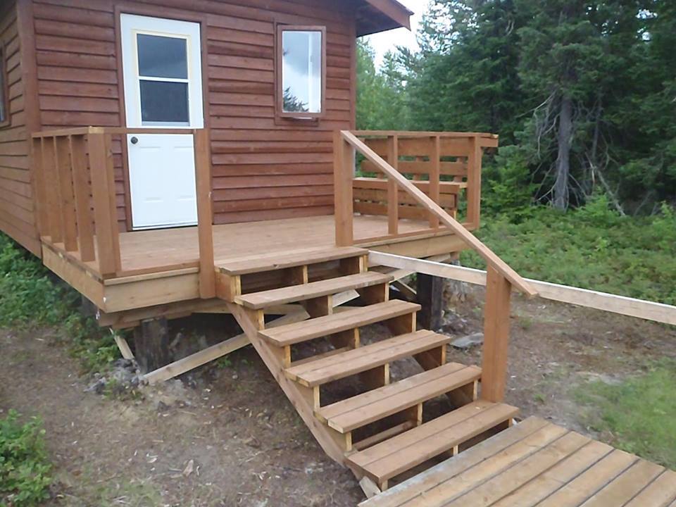 A wooden cabin with stairs leading up to it