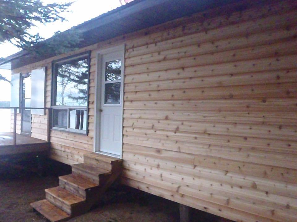 A wooden house with stairs and a white door