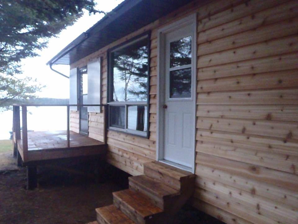 A wooden house with a white door and stairs