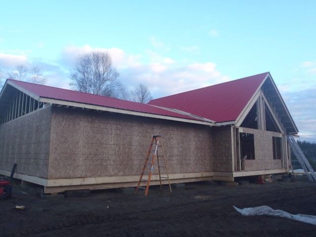 A house under construction with a red roof