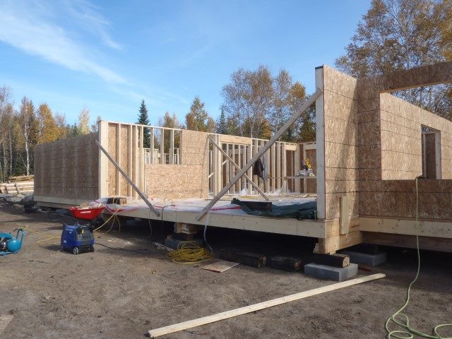 A house is being built on a trailer in a parking lot