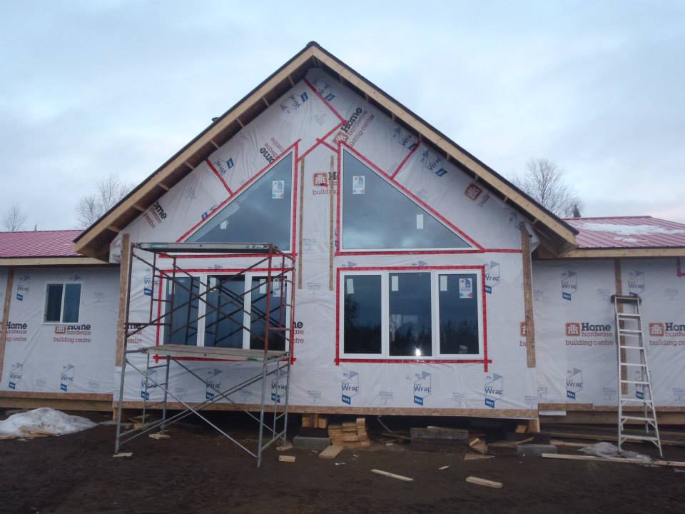 A house that is being built with a lot of windows