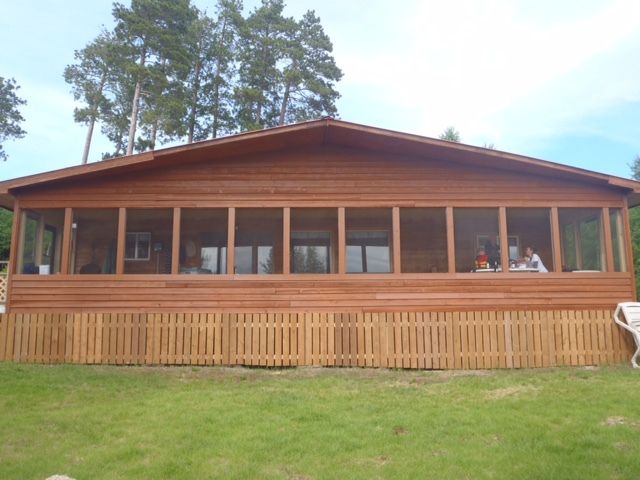 A large wooden house with lots of windows and a screened in porch