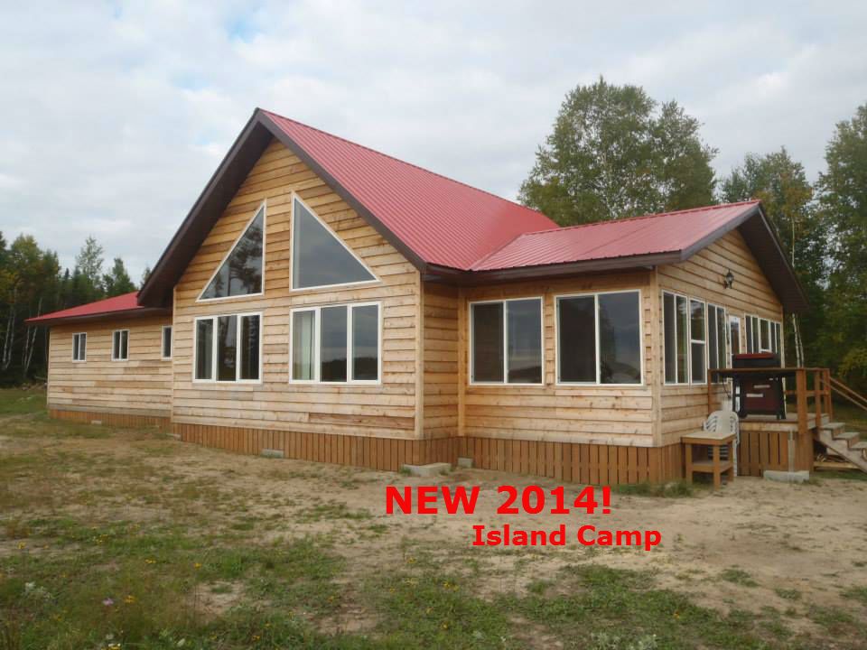 A large wooden house with a red roof that says new 2014 island camp