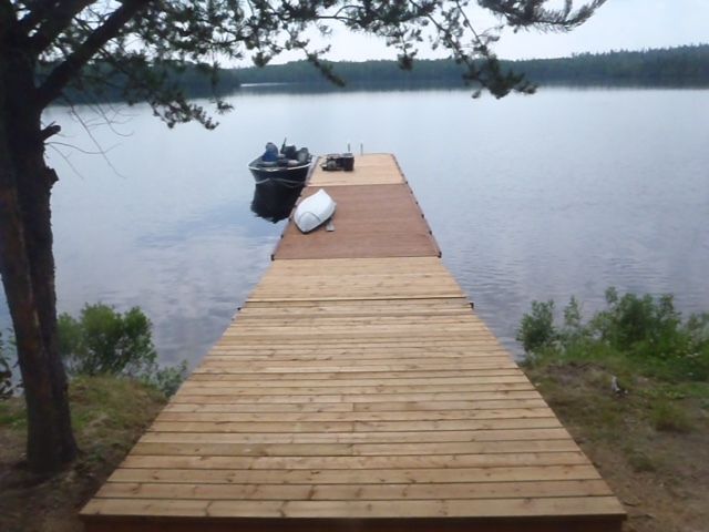 A boat is docked at the end of a wooden dock