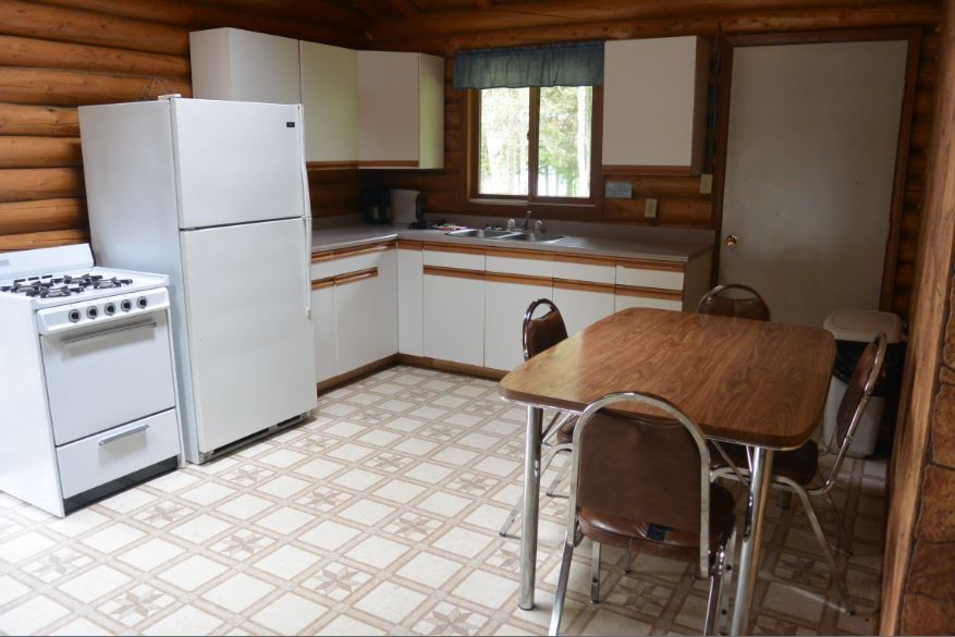 A kitchen with a table and chairs and a refrigerator